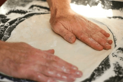 Hand-stretching 48-hour fermented dough