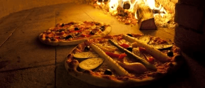 Pizzas cooking inside the woodfired oven